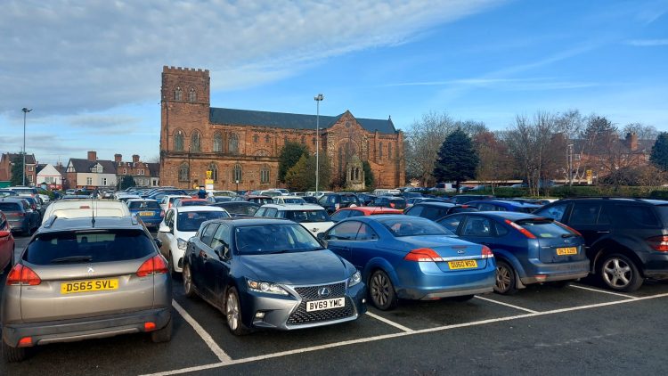 Cars parked in Abbey Foregate car park in Shrewsbury with the Abbey in the background