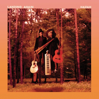 An image of two people in woodland with two guitars and a keyboard.