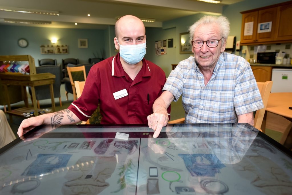Coverage Care Services invests in My Life TV to support residents living with dementia. Pictured is Thomas Groves and Bryan Donnell from Briarfields in Shrewsbury with the interactive digital tables which are being used to stream My Life TV programmes and activities.