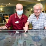 Coverage Care Services invests in My Life TV to support residents living with dementia. Pictured is Thomas Groves and Bryan Donnell from Briarfields in Shrewsbury with the interactive digital tables which are being used to stream My Life TV programmes and activities.