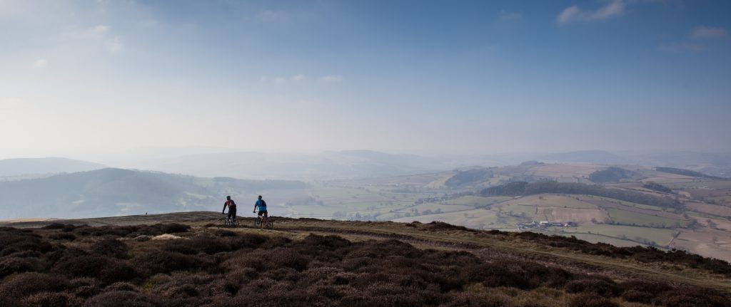 An image of two cyclists on The Portway on the Long Mynd in the Shropshire Hills on a sunny day.
