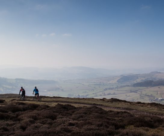 An image of two cyclists on The Portway on the Long Mynd in the Shropshire Hills on a sunny day.