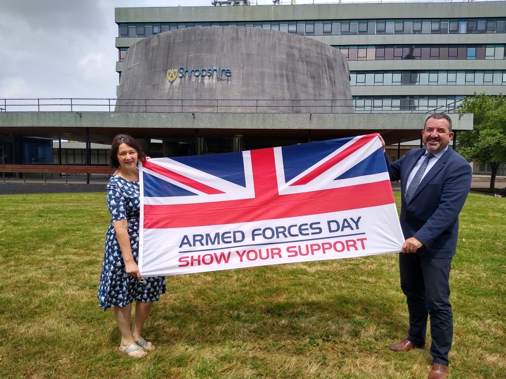 An image of Shropshire Council's interim acting chief executives standing 2m apart holding the Armed Forces Day flag.