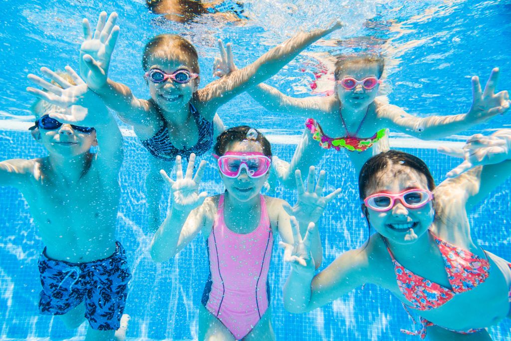little kids swimming in pool underwater.