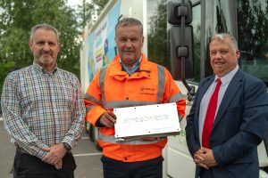 Councillors Ian Nellins and Richard Overton pictured with Ian Hancock and the Streetwave surveying equipment which is a silver couloured box. A  refuse collection vehicle is in the background.