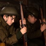 Two boys dressed in World War One ground unit military uniform holding rifles during their site visit as part of the In the Hands of Boys project coordinated by Shropshire Council.