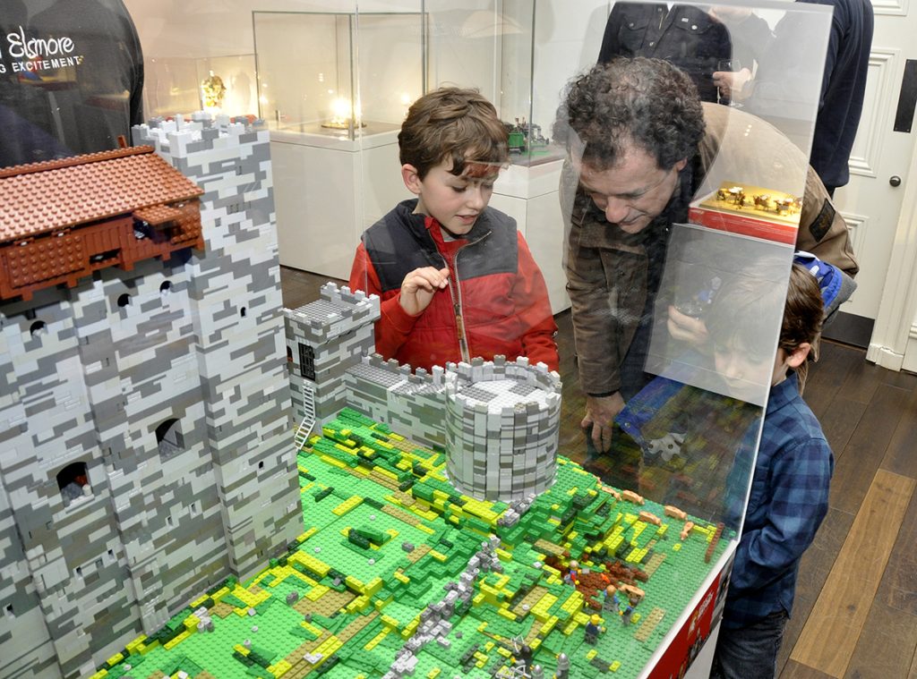 An image of a father and his son looking at the Lego model of Rochester Castle with intrigue in the Brick History exhibition that was at Shrewsbury Museum and Art Gallery from 12 February to 15 April 2018.