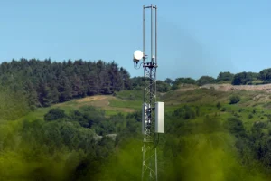 A Vodaphone mast against blue sky and countryside