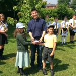 2 children and an adult in a field with a bowl