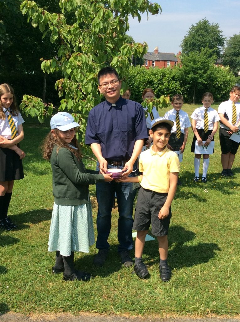 2 children and an adult in a field with a candle