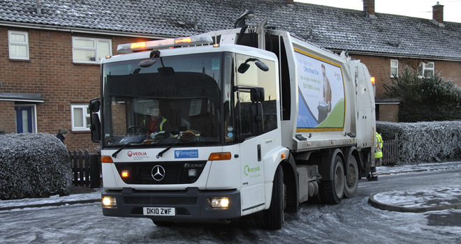 A bin lorry on a snowy street