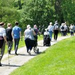 Many people walking in a park, for Carers Week 2021
