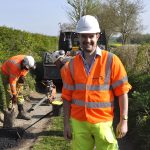 Councillor Dean Carroll in a country lane where find and fix potholes repairs are taking place