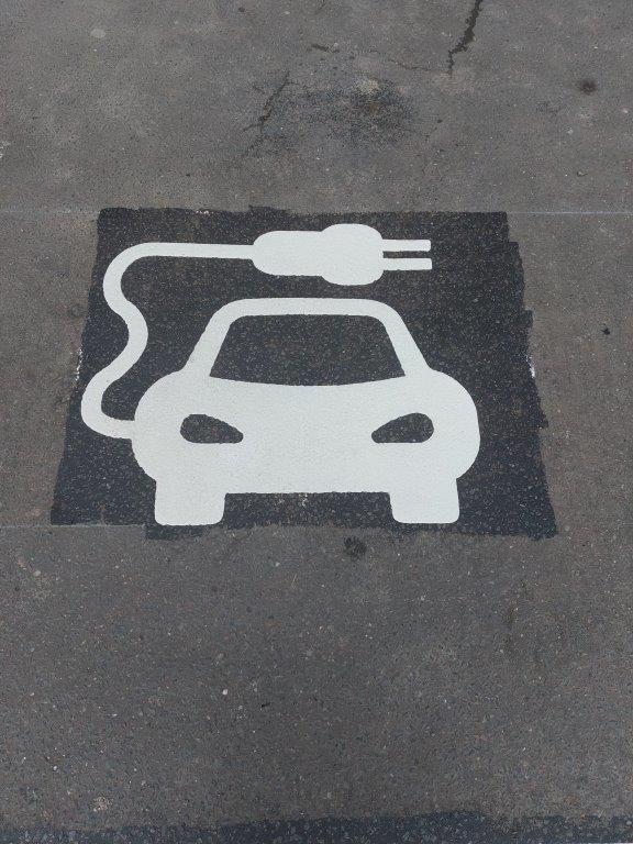 Electric vehicle charger space sign painted on road