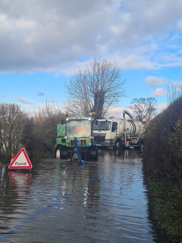Crews clearing flood water on the road between Atcham and Crosshouses.
