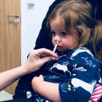Child receiving flu nasal spray