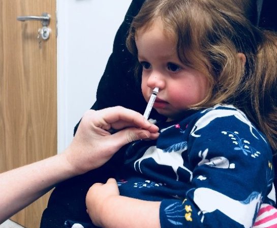 Child receiving flu nasal spray