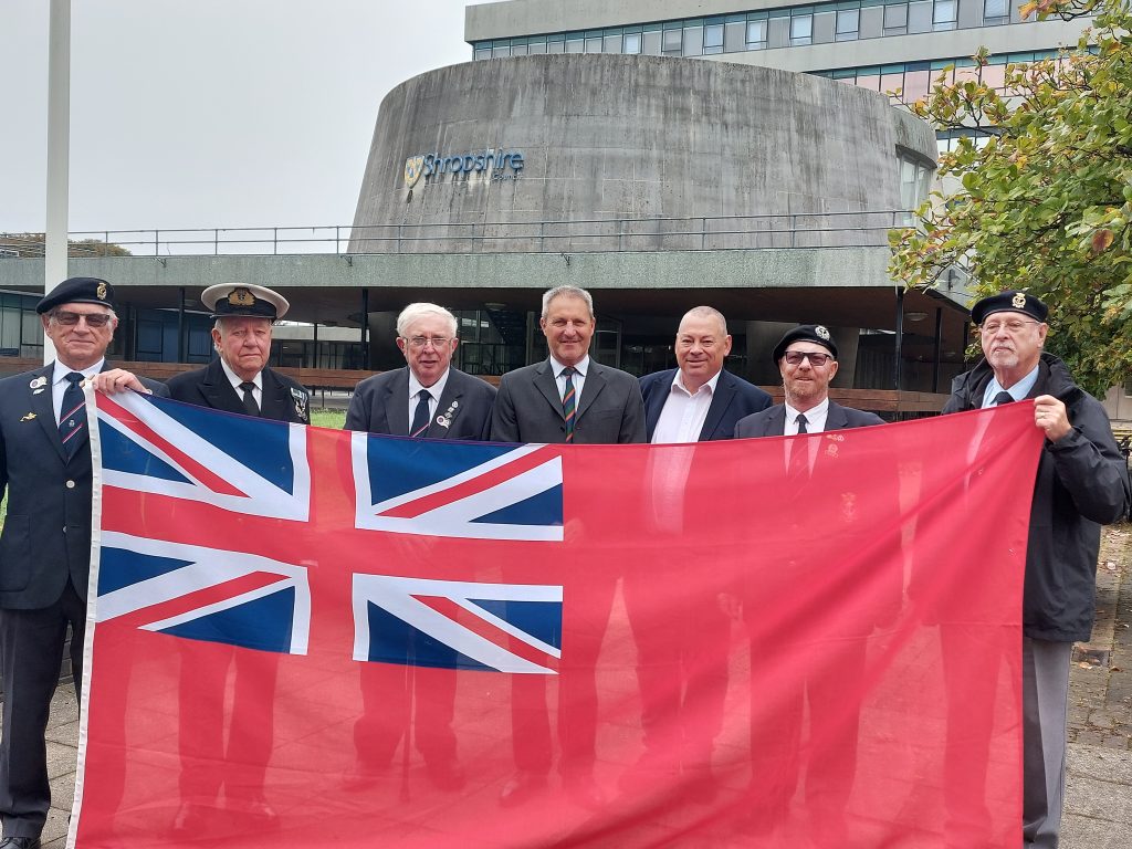 People with a flag for Merchant Navy Day 2023.