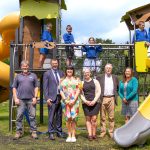 Children on a new play park, plus visiting adults