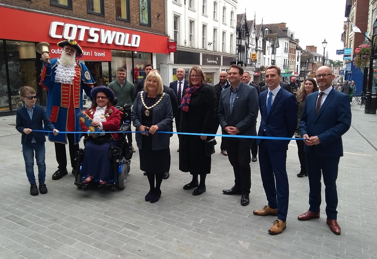 Councillor Ann Hartley, Chairman of Shropshire Council, cuts the ribbon at the top of Pride Hill, watched by Martin Wood, town crier, and representatives from Shropshire Council, Shrewsbury Town Council, Shrewsbury BID and McPhillips.