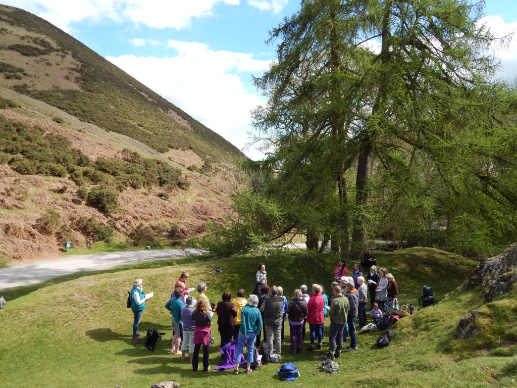 An image of a group of people singing in Carding Mill Valley which sits in the heart of the Shropshire Hills Area of Outstanding Natural Beauty.