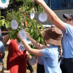 Pupils dressing the memorial tree with messages of remembrance and hope