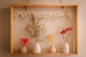 Some fabric bunting with the letters WELCOME and dried flowers in vases underneath