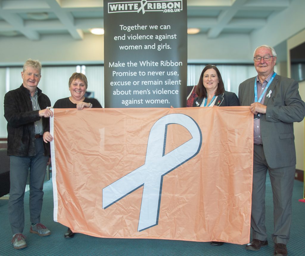 The White Ribbon accreditation and flag. From left: Councillors Julian Dean, Lezley Picton, Julia Buckley, Roger Evans